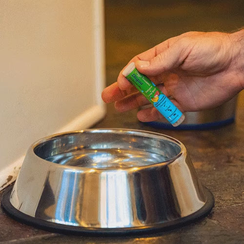 A dose of Dogua banana mix being added to a dog's water bowl
